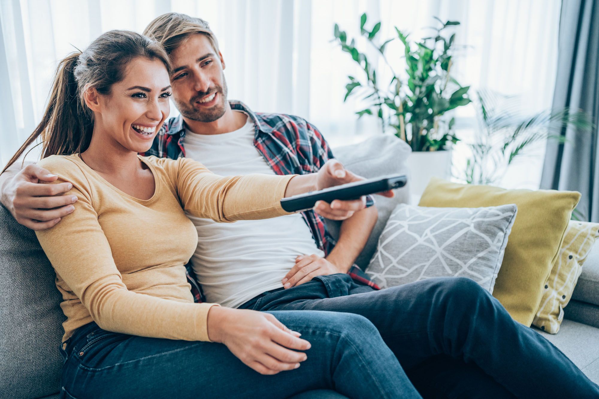 Paar sitzt auf der Couch und sieht fern