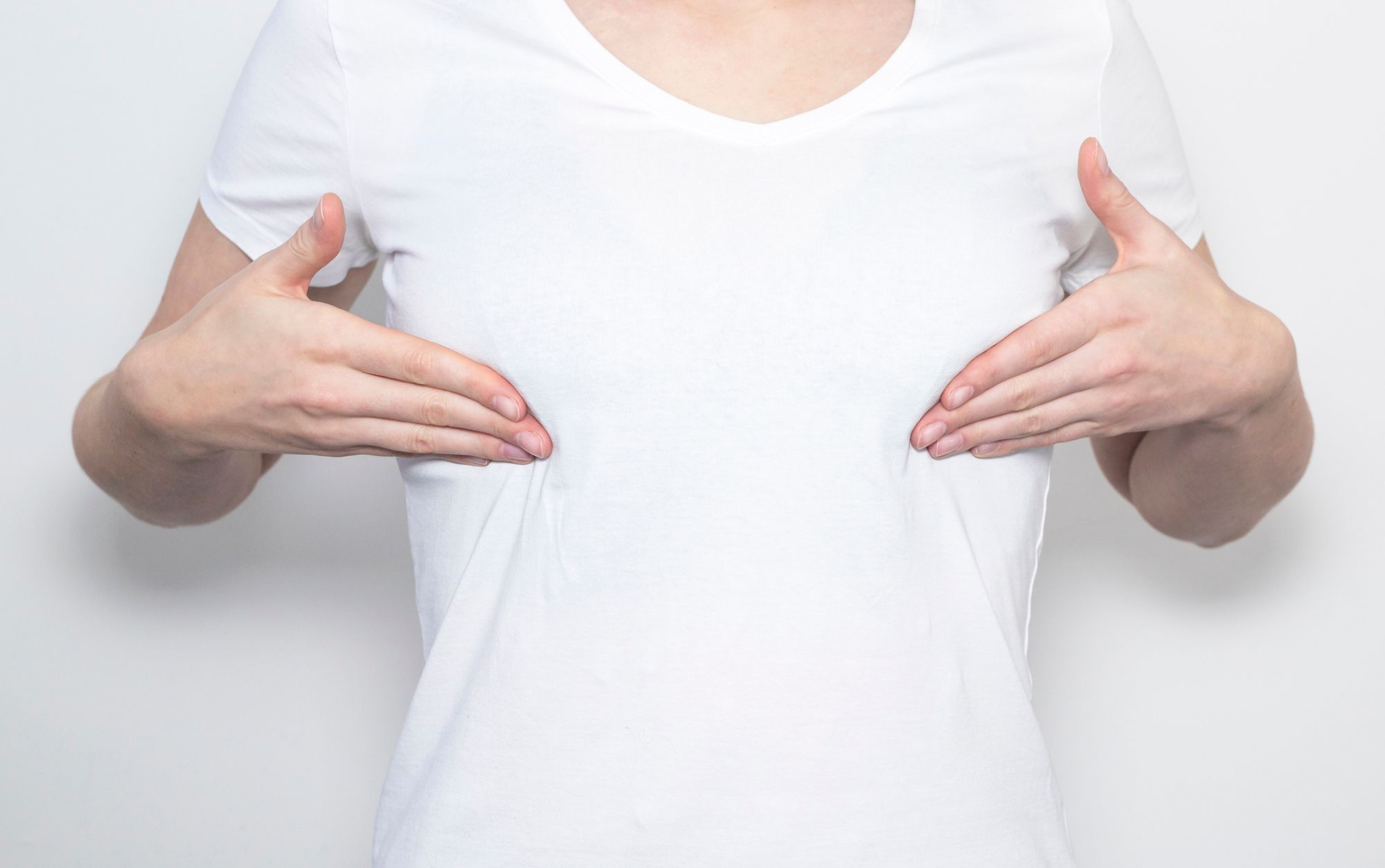 Frau im T-Shirt langt sich an die Brüste