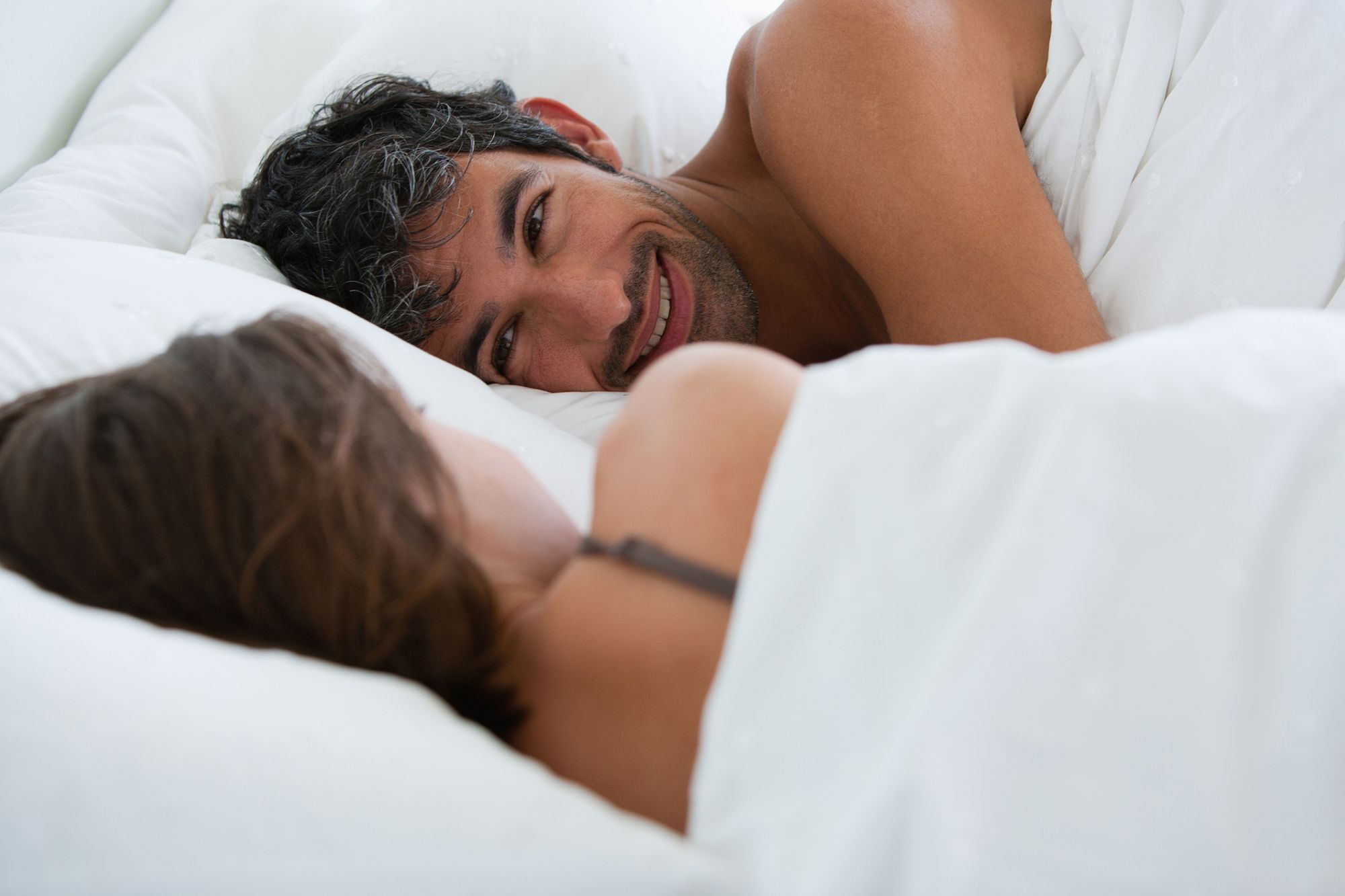 Mann und Frau liegen einander zugewandt im Bett