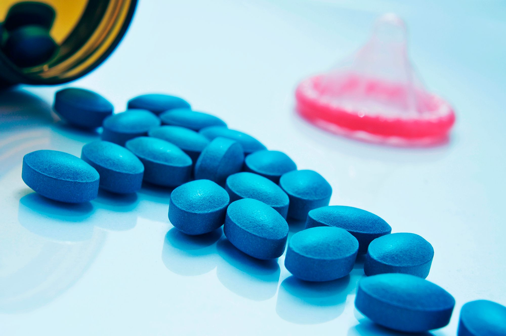 Wer hat Viagra erfunden - Abbildung vieler blauer Pillen auf einer weißen Oberfläche.
