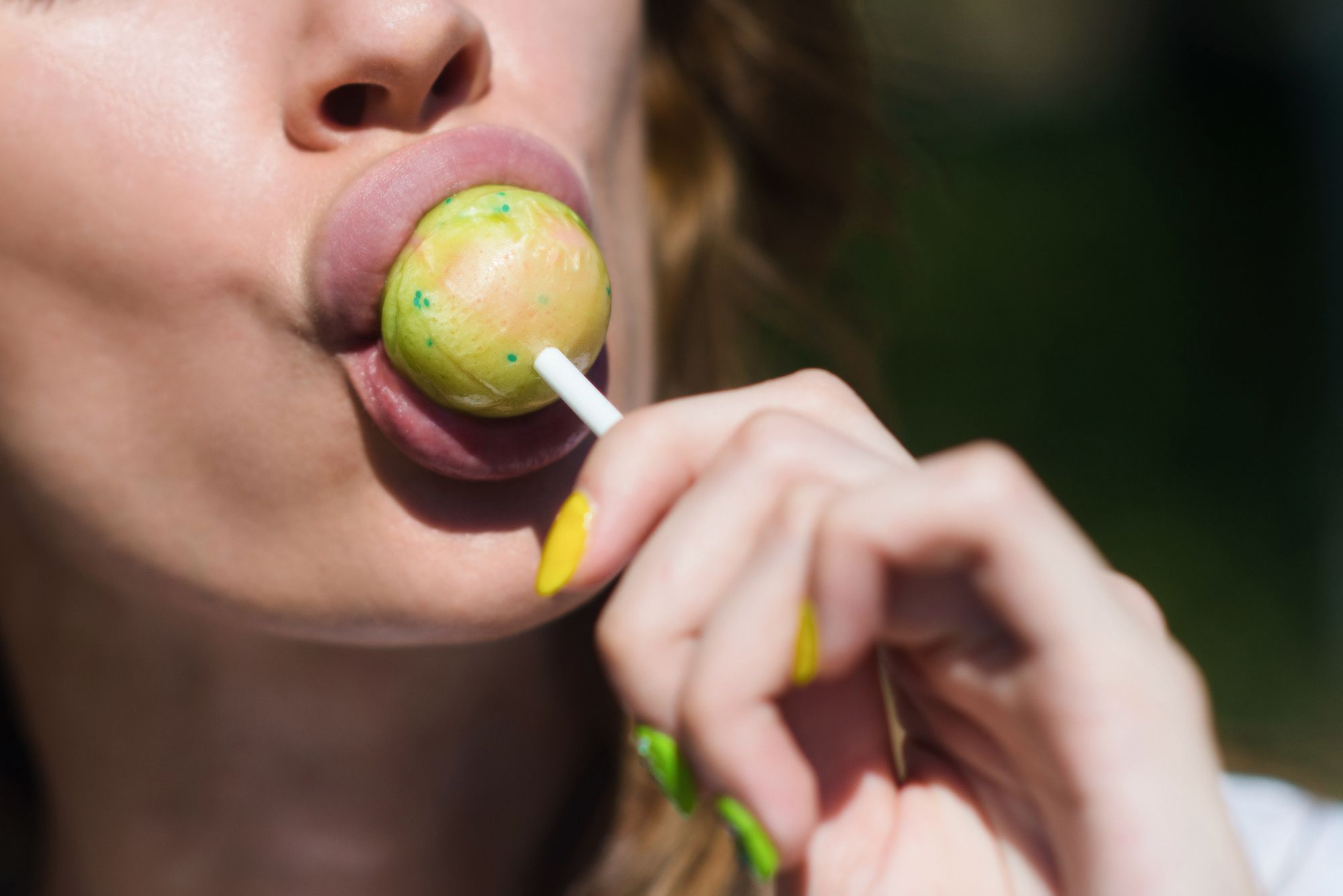 Frau leckt intensiv an einem Lolli