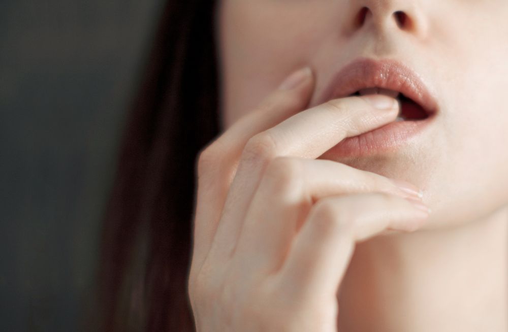 Eine Frau beißt sich auf einen Finger