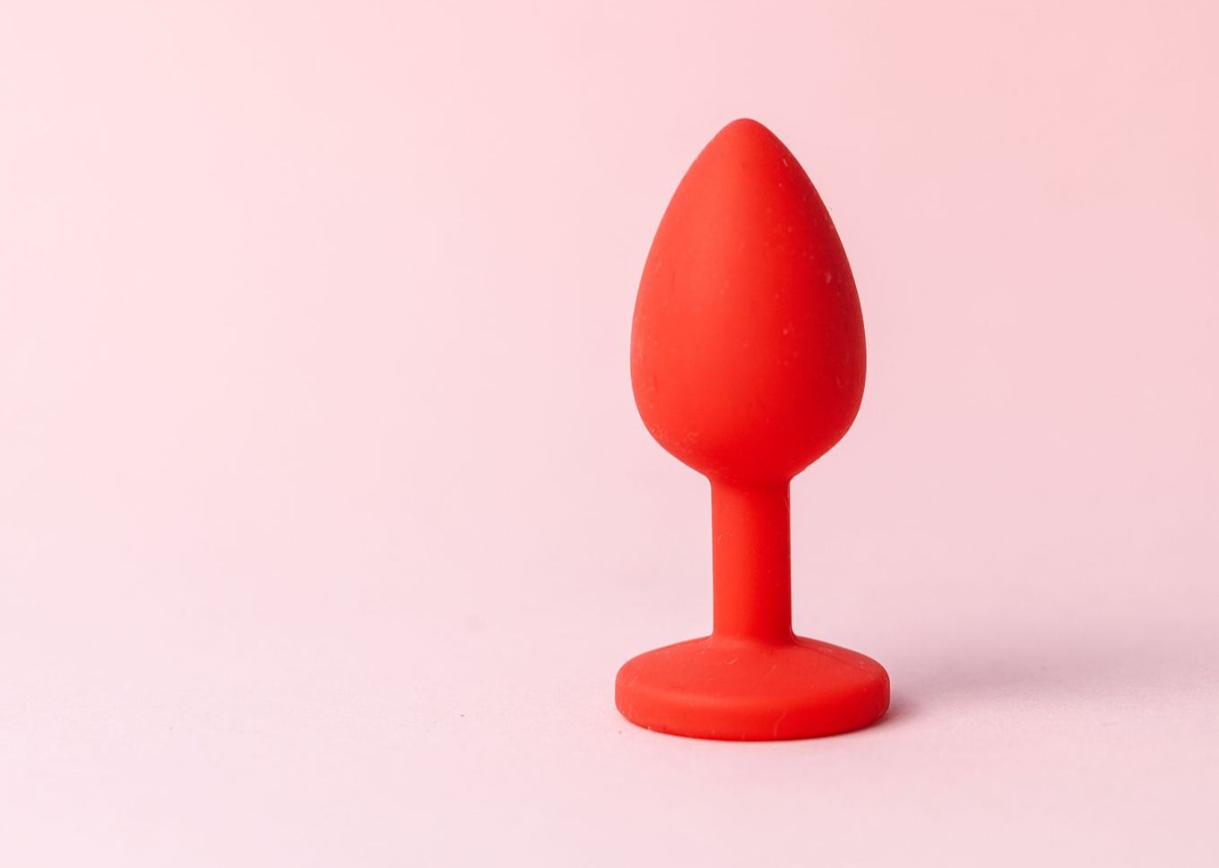 Roter Analplug vor rosa Hintergrund