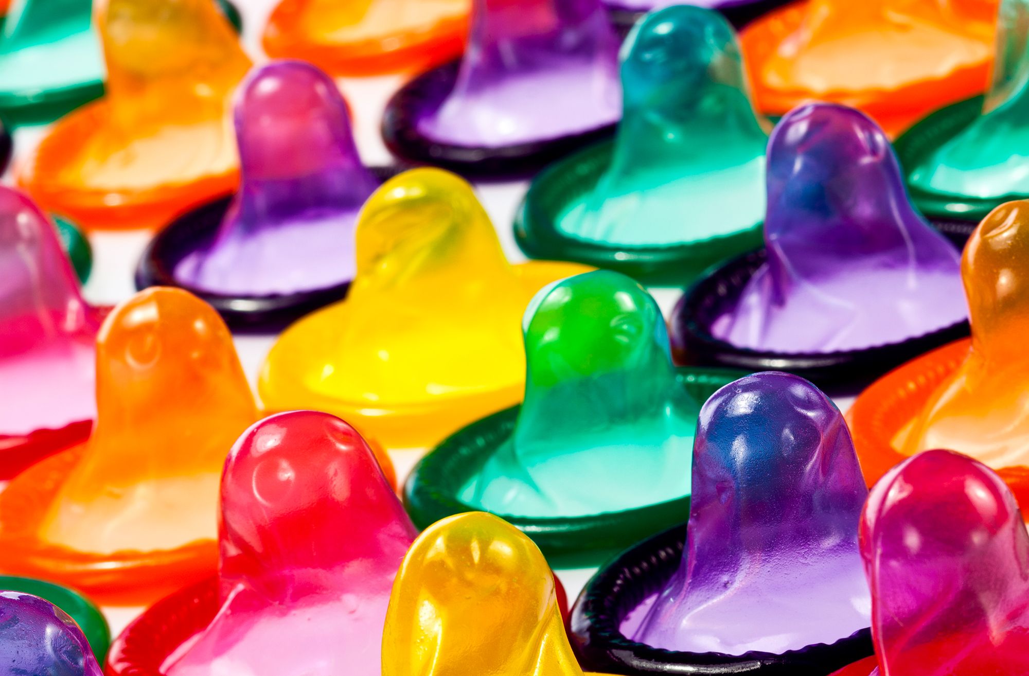 Noppen Kondom - Abbildung vieler bunter, entpackter Kondome von oben.