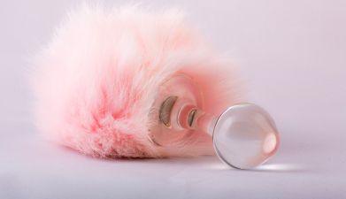 Ein Analplug aus Glas mit einem rosa Schweif daran