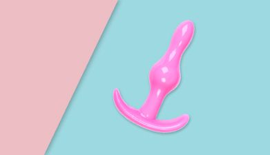 Ein pinker Analplug vor einem rosa-türkisen Hintergrund