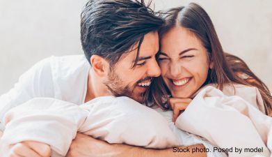 Eine Frau und ein Mann die ihre Köpfe aneinanderhalten und lachen