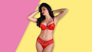 Dunkelhaarige Frau in roter High Waist Unterwäsche 'Floral Lace' von Daring Intimates vor pink-gelbe