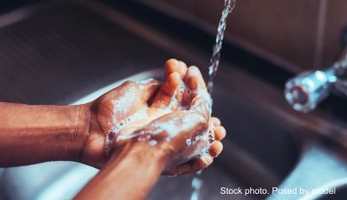 Eine Person die sich die Hände in einer Spüle wäscht