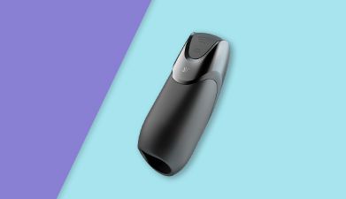 Schwarzer Bluetooth Masturbator Satisfyer 'Men Vibration+' auf lila-türkis geteiltem Hintergrund