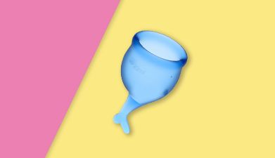 Blauer Satisfyer 'Feel Secure Menstrual Cup' Menstruationstasse vor pink-gelbem Hintergrund