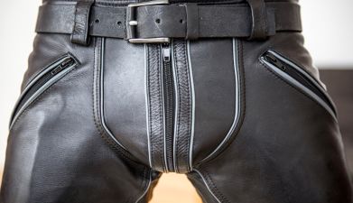 Ein Mann, der eine im Schritt verstärkte schwarze Lederhose an hat