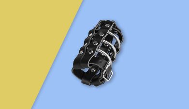 Schwarzer Peniskäfig mit Schloss von EIS vor gelb-blauem Hintergrund