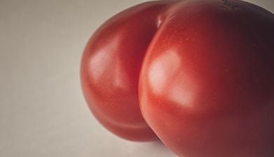Eine Tomate die wie ein Po aussieht vor einem hellen Hintergrund