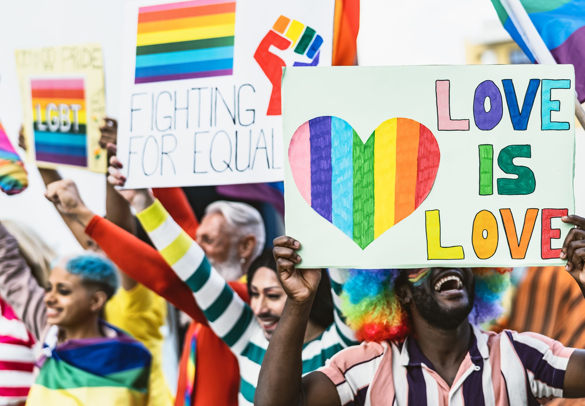 Menschen auf einer Demonstration die queere Schilder halten