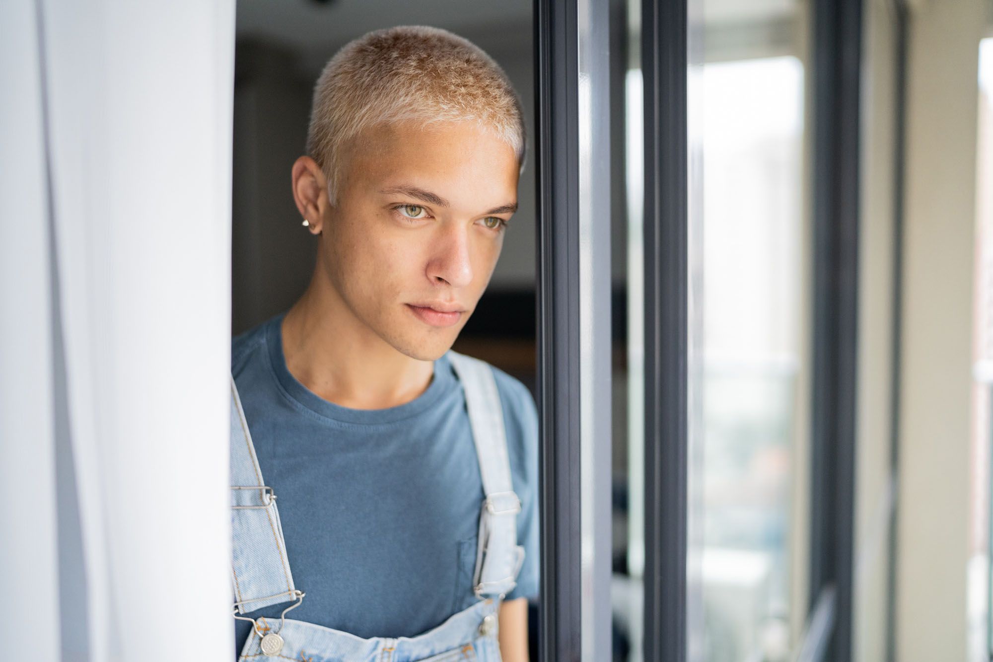 Mann schaut nachdenklich aus dem Fenster