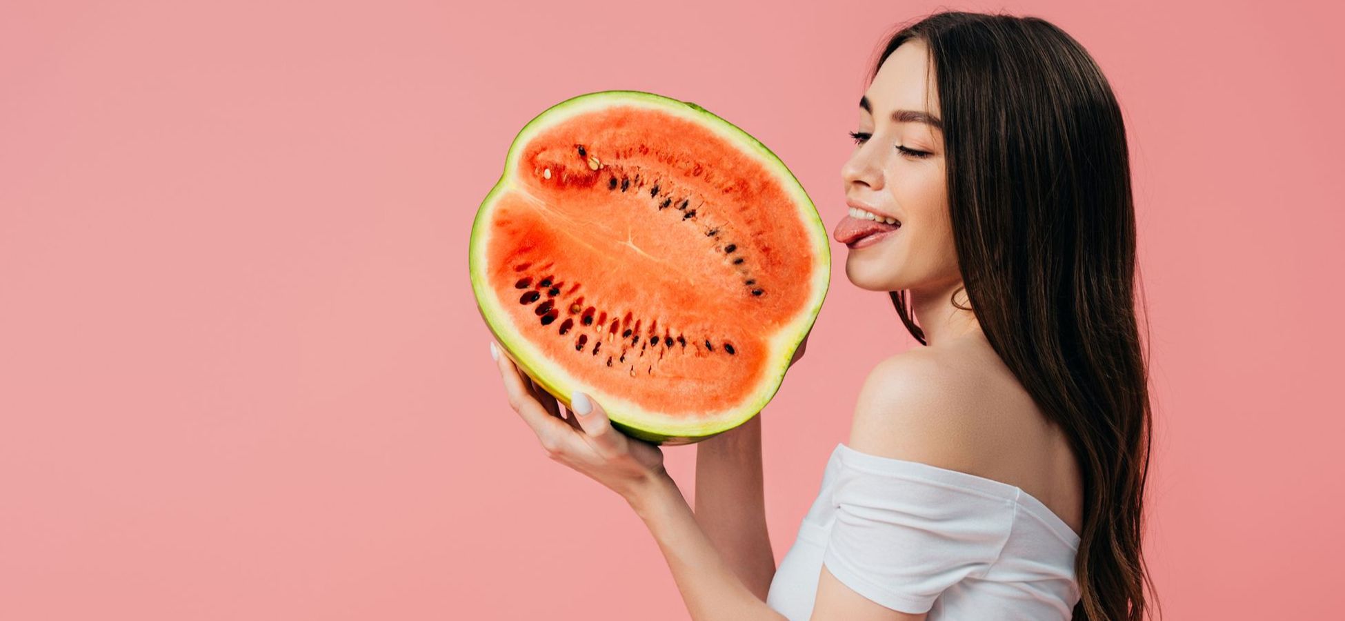 Frau leckt an einer halben Melone