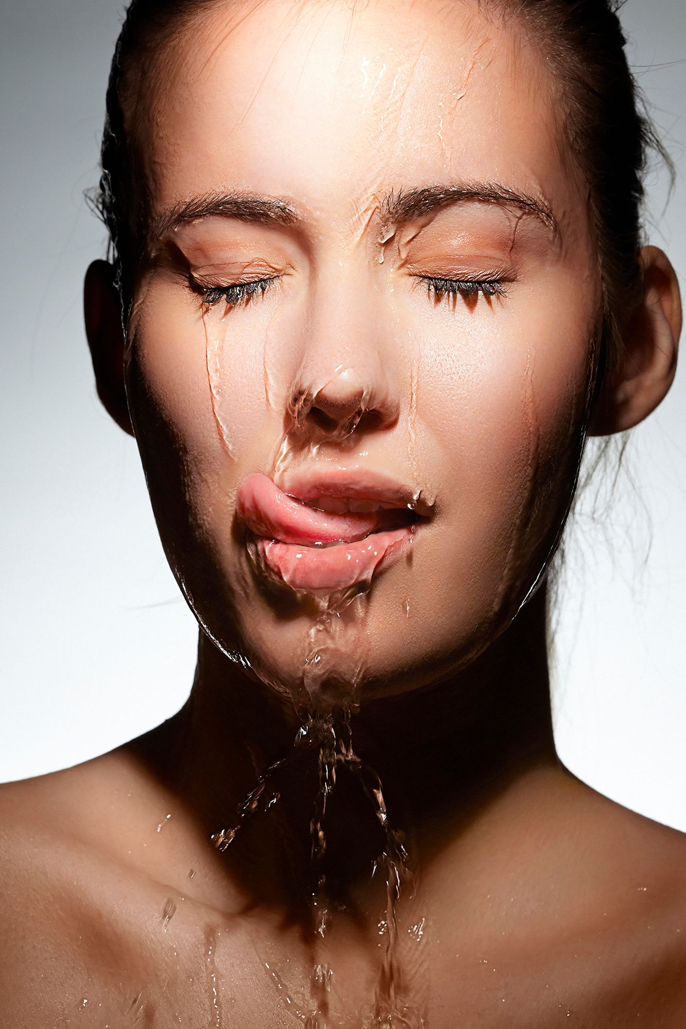 Eine Frau der Wasser über das Gesicht läuft