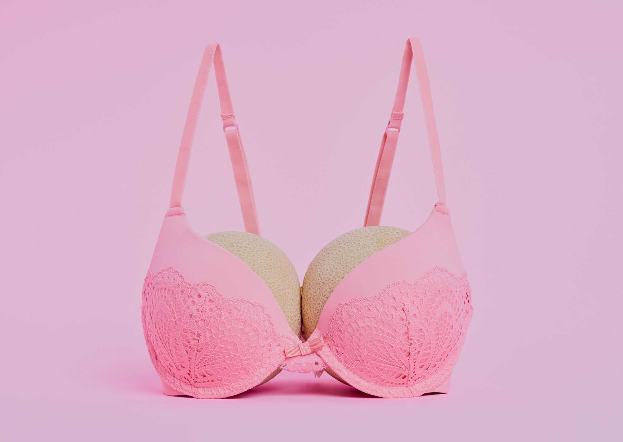 Pinker BH mit zwei Bällen auf rosa Hintergrund