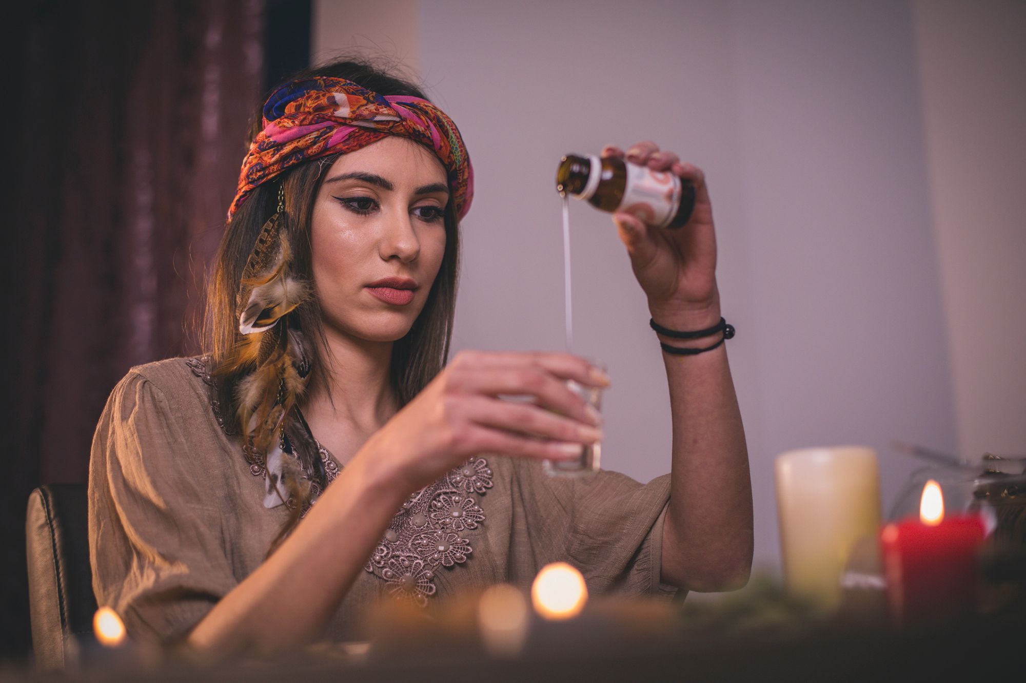 Frau mit Bandana, die Öl in ein Glas gießt