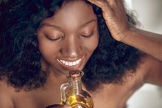 Frau riecht an einer Flasche mit Massageöl
