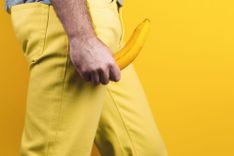 Penis in Unterhose - Abbildung eines männlichen, bekleideten Unterkörpers, welcher mit einer Banane als Penis-Attrappe einen erigierten Penis andeutet.