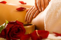 Massage eines Rückens im Vordergrund eine Rose