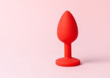 Roter Analplug vor rosa Hintergrund
