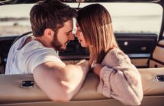 Junger Mann und junge Frau sind kurz davor, sich im Auto zu küssen
