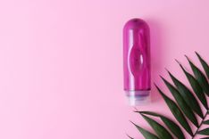 Gleitgel auf rosa Hintergrund mit grünem Farn