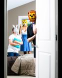 3 Personen mit Tiermasken in einem Schlafzimmer