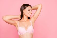Brünette Frau in rosa BH vor einem rosa Hintergrund