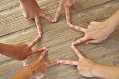 3 Menschen bilden einen Stern aus ihren Fingern
