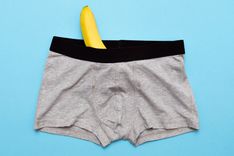 Graue Unterhose aus der eine Banane hervorschaut.