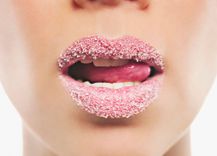 Frau mit Zucker auf den Lippen leckt sich die Lippen