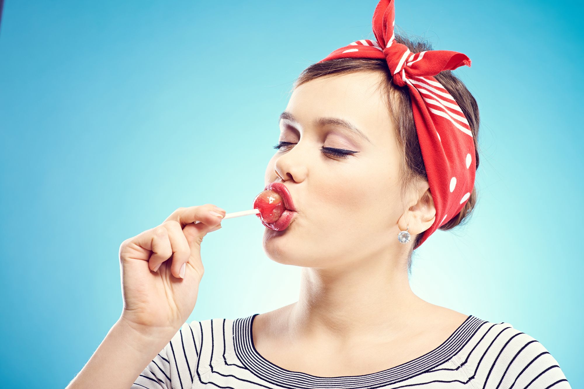 Frau leckt mit geschlossenen Augen an einem Lolli